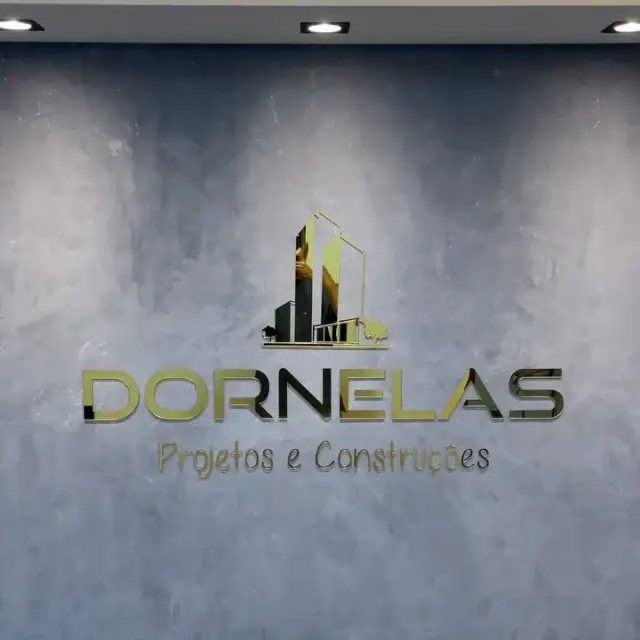 Logomarca Dornelas dourada aplicada em parede cinza