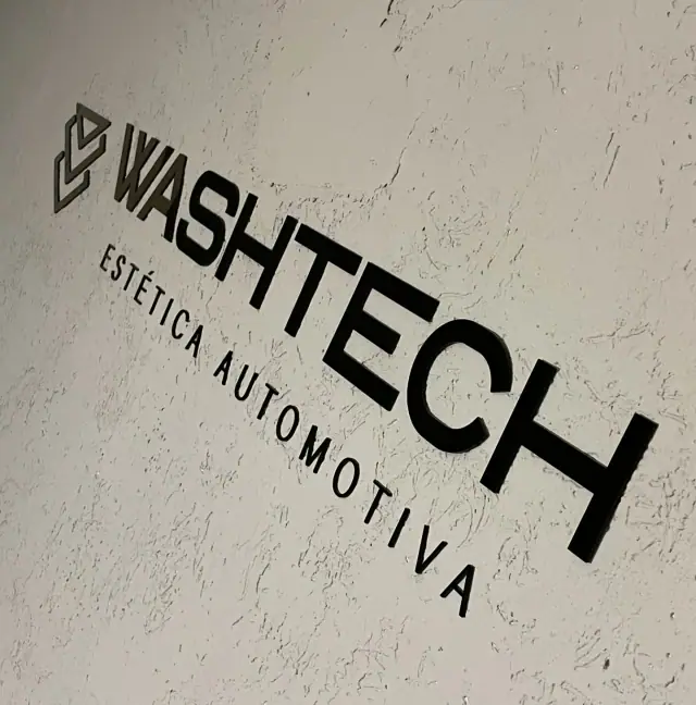 Letras escuras da marca Washtech sobre parede clara