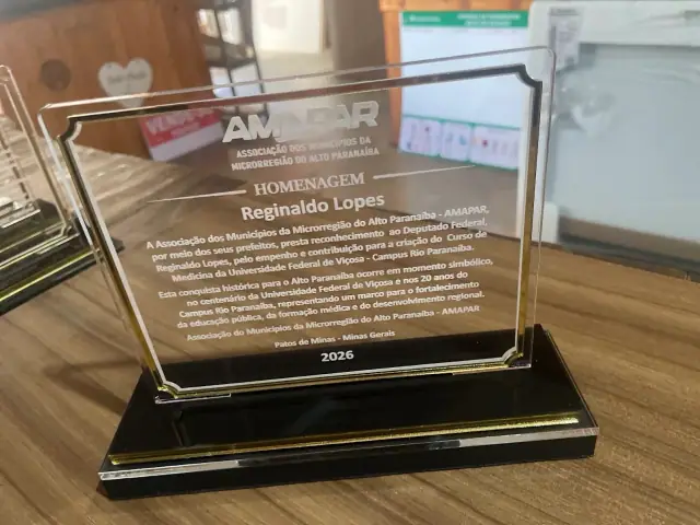 Placa transparente retangular com homenagem gravada sobre base preta