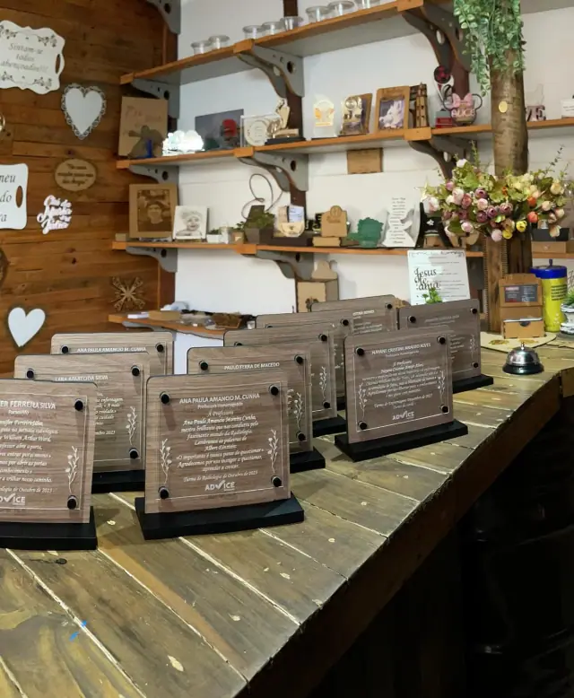 Placas de homenagem organizadas em lote sobre a bancada
