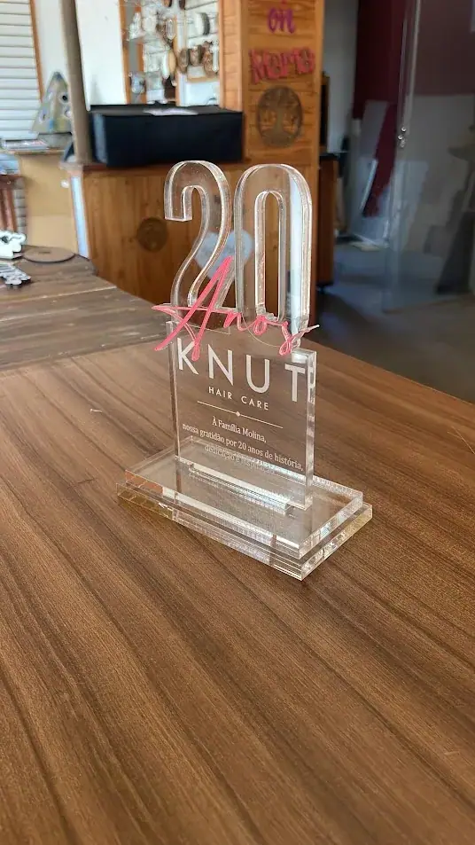 Troféu transparente com número 20 e letras KNUT sobre base retangular