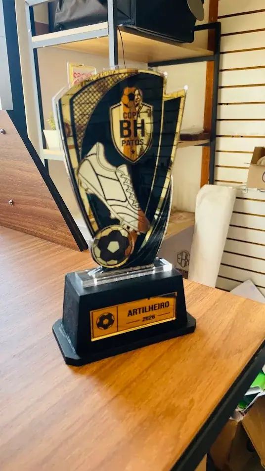 Troféu preto e dourado com chuteira, bola de futebol e placa Artilheiro
