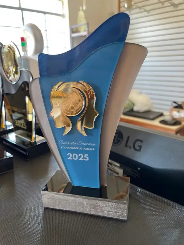 Troféu azul com medalhão dourado de perfil humano e ano 2025