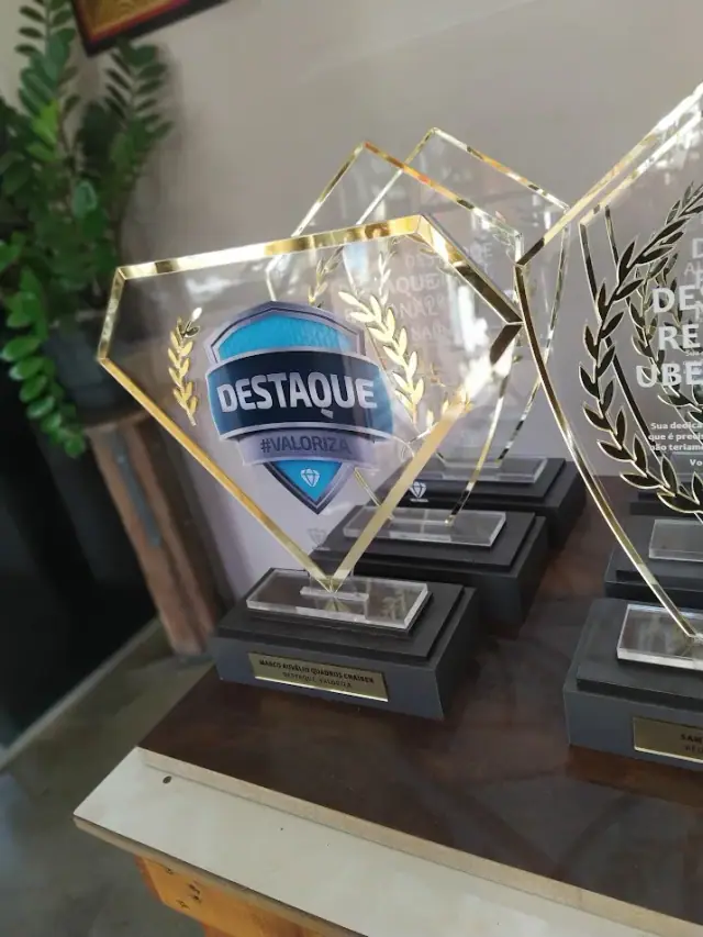 Troféus transparentes com contorno dourado e inscrição Destaque