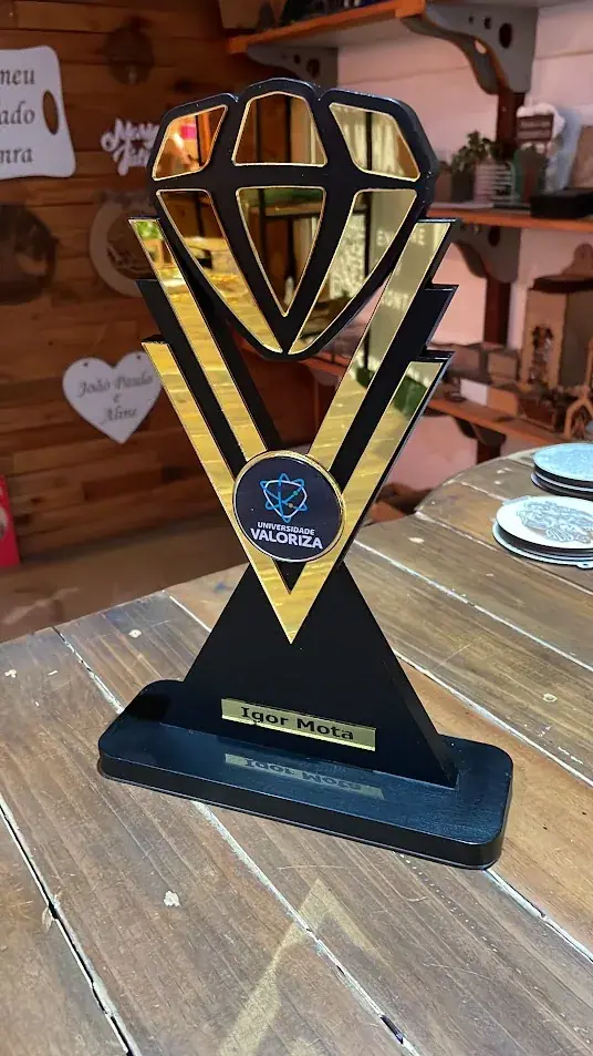 Troféu preto e dourado com recorte de diamante visto de frente na oficina