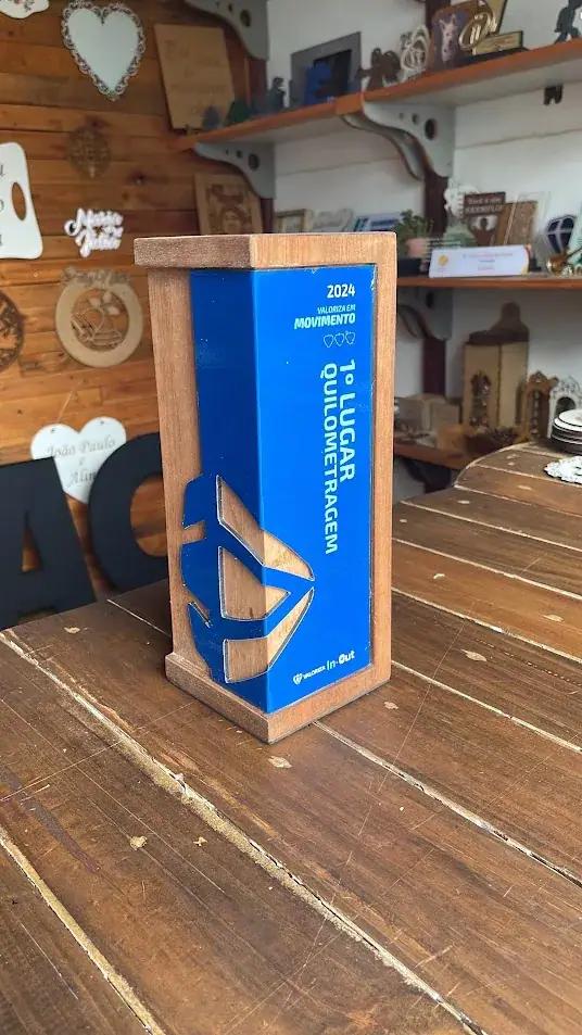 Troféu vertical azul com identidade visual e detalhes claros recortados