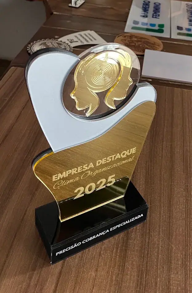 Troféu branco e dourado com inscrição Empresa Destaque 2025 sobre base preta