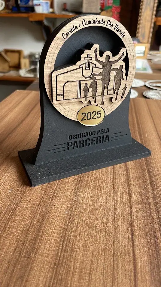 Troféu com pessoas caminhando, ano e mensagem de agradecimento pela parceria